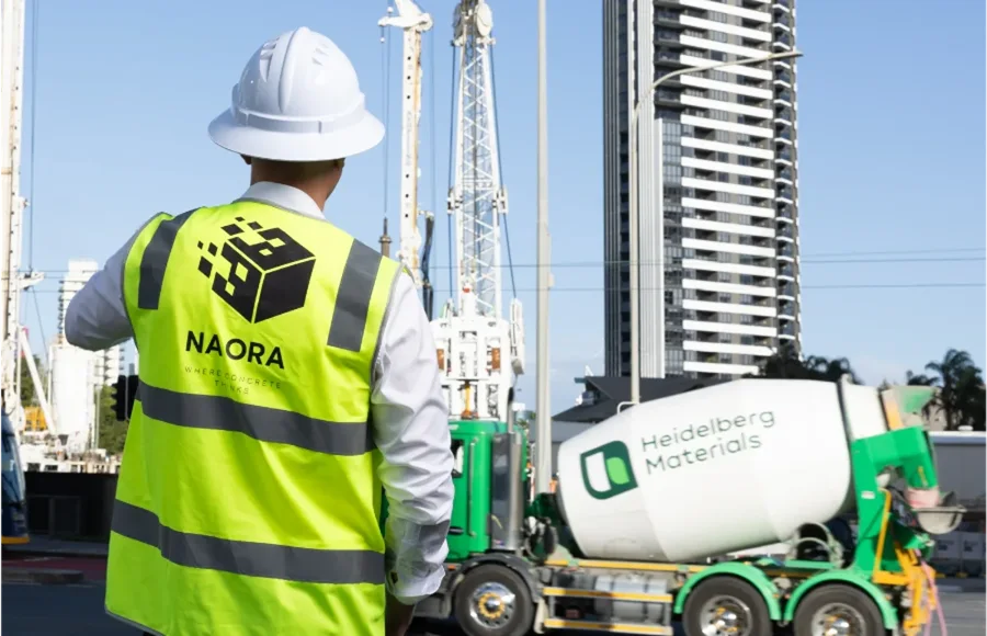NAORA site supervisor in branded hi-vis monitoring a live concrete delivery on a Gold Coast commercial project.